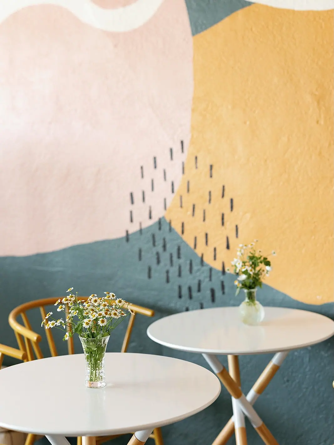 Fresh flowers and small tables styled for a celebration at Coastal Coworking