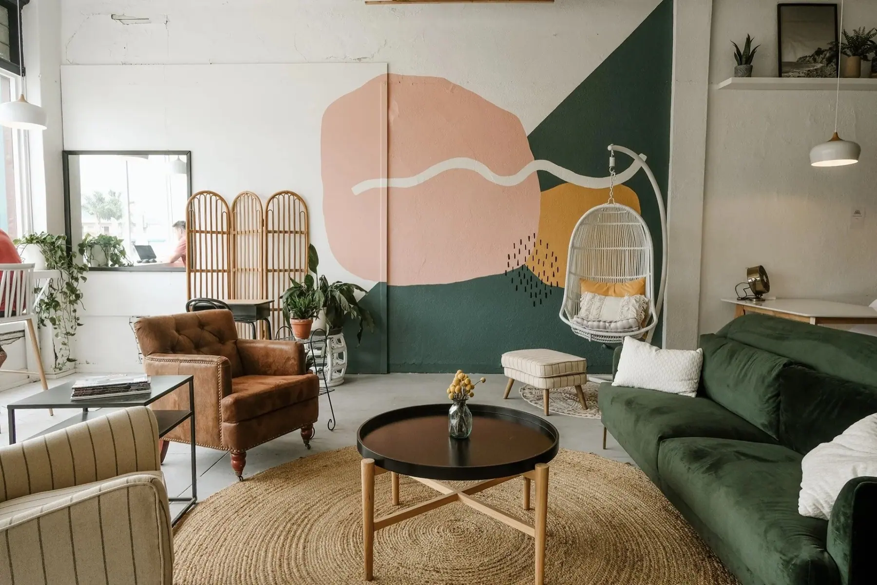 The plant-filled lounge and wave mural inside Coastal Coworking